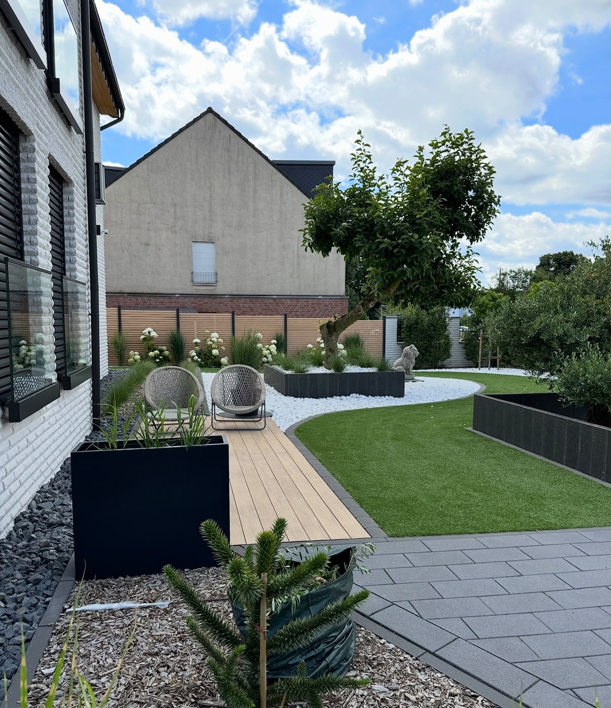 Von GaLaBau Loos angelegter Garten mit geschwungener Kunstrasenfläche
